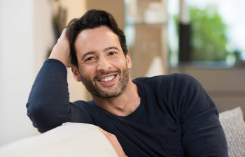 smiling middle aged man sitting on couch, 